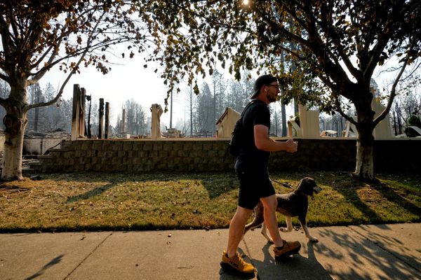 Một người đàn ông đi ngang qua một ngôi nhà bị cháy do cháy rừng ở Spokane, bang Washington - Sputnik Việt Nam