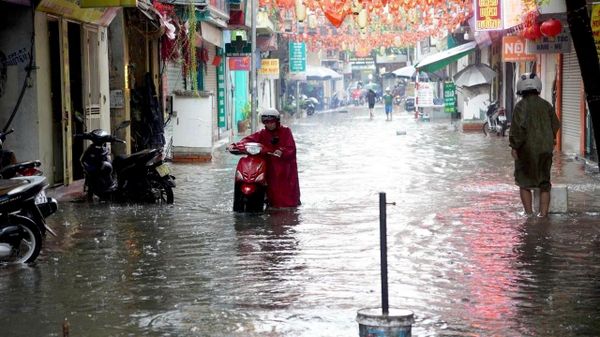 Tại các điểm ngập nước, một số xe bị chết máy, người dân phải dắt bộ qua các điểm ngập úng. - Sputnik Việt Nam