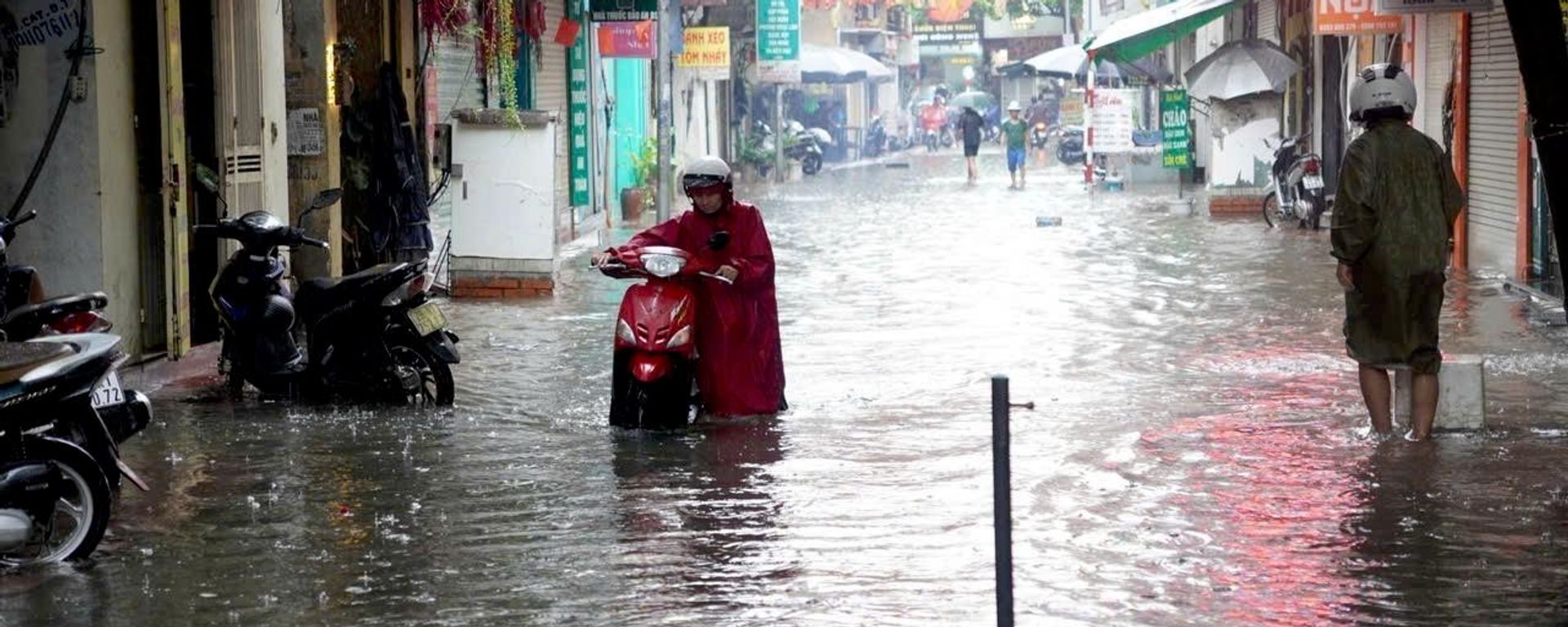 Tại các điểm ngập nước, một số xe bị chết máy, người dân phải dắt bộ qua các điểm ngập úng. - Sputnik Việt Nam, 1920, 08.08.2026