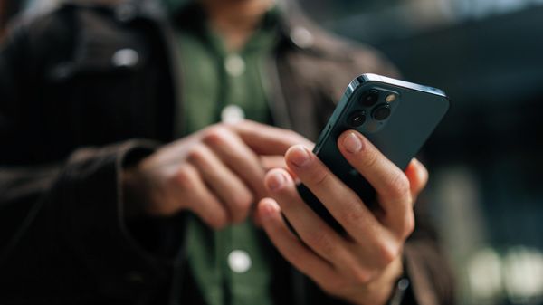 Một người đàn ông đang xem điện thoại di động của mình - Sputnik Việt Nam