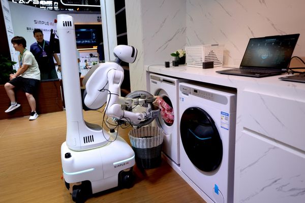 Robot của Simple AI trình diễn cách lấy quần áo từ máy giặt tại Hội nghị robot thế giới 2026 ở Bắc Kinh, Trung Quốc. - Sputnik Việt Nam
