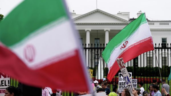 Demonstrators carry signs and wave the Iranian flag as they rally outside the White House, Sunday, June 22, 2025, in Washington, to protest the U.S. military strike on three sites in Iran early Sunday.  - Sputnik Việt Nam
