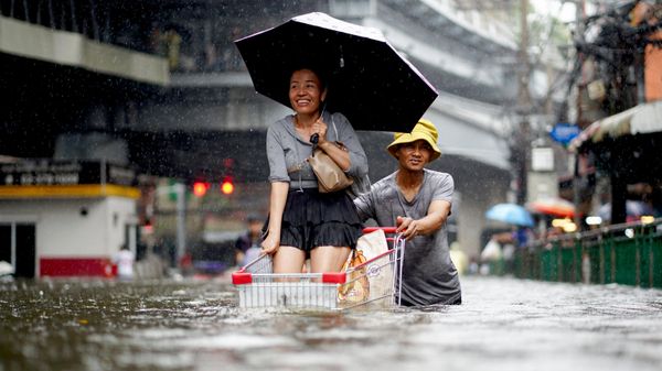 Người dân đẩy xe hàng trên con phố ngập nước ở Bangkok. - Sputnik Việt Nam