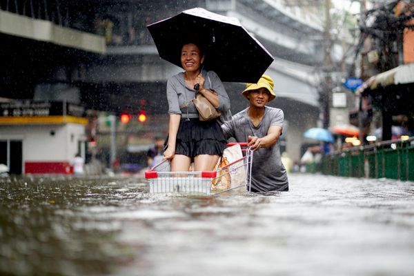 Người dân đẩy xe hàng trên con phố ngập nước ở Bangkok. - Sputnik Việt Nam