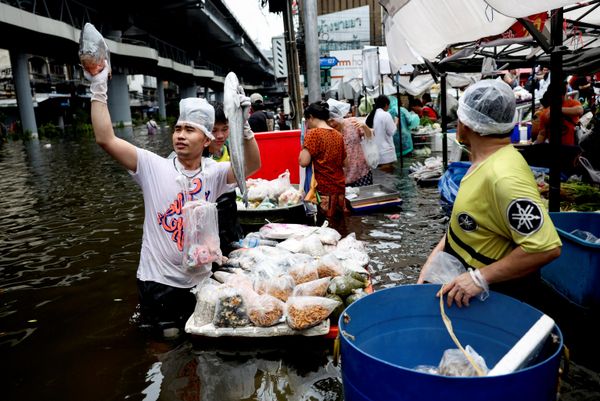 Những người bán hàng cùng hàng hóa trên con phố ngập nước ở Bangkok. - Sputnik Việt Nam