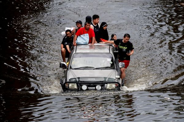 Người dân ngồi trên xe bán tải giữa con phố ngập nước ở Bangkok. - Sputnik Việt Nam