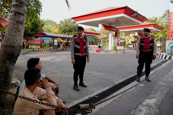 Cảnh sát canh gác một trạm xăng đã đóng cửa trong bối cảnh thiếu nhiên liệu ở Denpasar, Indonesia. - Sputnik Việt Nam