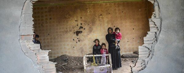 Người phụ nữ cùng đứa con trong ngôi nhà bị phá hủy, Silopi, Thổ Nhĩ Kỳ. Người phụ nữ cùng đứa con trong ngôi nhà bị phá hủy, Silopi, Thổ Nhĩ Kỳ. - Sputnik Việt Nam