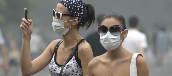 Các cô gái đeo khẩu trang chụp ảnh trên điện thoại Các cô gái đeo khẩu trang chụp ảnh trên điện thoại - Sputnik Việt Nam
