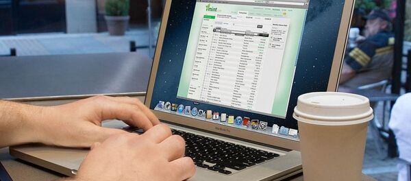 Một người đàn ông làm việc trên laptop trong quán cà phê - Sputnik Việt Nam