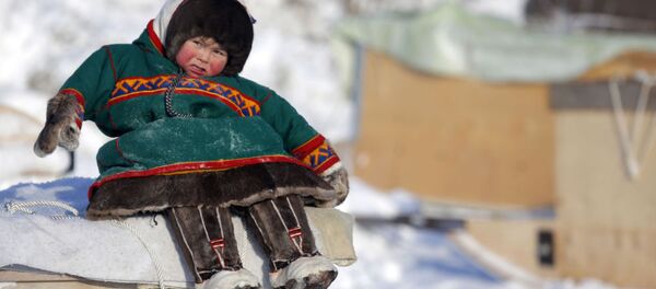 Маленький ненец сидит на санях в День оленевода в городе Надым - Sputnik Việt Nam