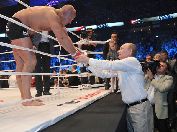 Tổng thống Nga Vladimir Putin (phải) tại giải đấu võ thuật hỗn hợp M-1 Global Đêm trắng tại St Petersburg, nơi cuộc đấu chính do võ sĩ Fedor Emelianenko thực hiện. - Sputnik Việt Nam