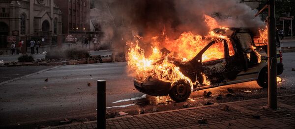 Горящий автомобиль в Йоханнесбурге, где прошли студенческие протесты - Sputnik Việt Nam