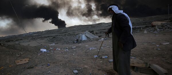 Một người tị nạn trên nền vụ nổ trong thời gian chiến dịch của quân đội Syria chống IS ở Mosul - Sputnik Việt Nam
