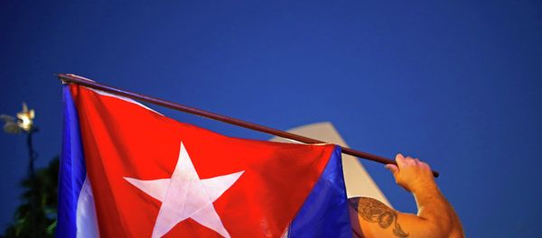 An anti-Castro Cuban exile holds a Cuban flag during a protest after the announcement of restoring diplomatic ties between Cuba and United States, at an area knows as 'Little Havana' in downtown Miami, Florida December 17, 2014. An anti-Castro Cuban exile holds a Cuban flag during a protest after the announcement of restoring diplomatic ties between Cuba and United States, at an area knows as 'Little Havana' in downtown Miami, Florida December 17, 2014. - Sputnik Việt Nam