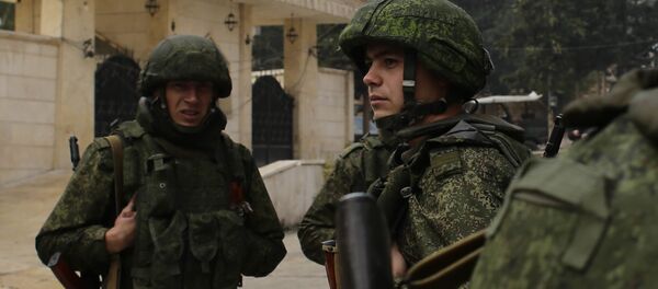 Russian soldiers stand next to an aid convoy in Aleppo, Syria, Sunday, Dec. 4, 2016 - Sputnik Việt Nam