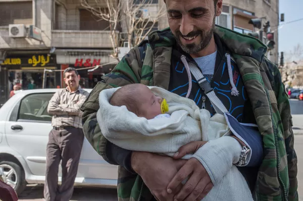 Người đàn ông với em bé trên đường phố Damascus sau khi công bố lệnh ngừng bắn Người đàn ông với em bé trên đường phố Damascus sau khi công bố lệnh ngừng bắn - Sputnik Việt Nam