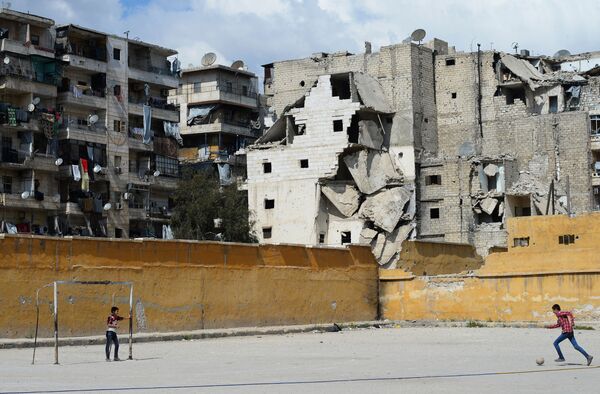 Các chàng trai chơi bóng đá trong khu phố Salah al-Din bị tàn phá của Aleppo - Sputnik Việt Nam