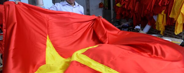 Quốc kỳ Việt Nam trong tay người thợ tại một xưởng sản xuất ở Hà Nội - Sputnik Việt Nam