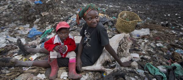 Người phụ nữ với một đứa trẻ thu nhặt rác trong bãi thải ở Nairobi, Kenya. Người phụ nữ với một đứa trẻ thu nhặt rác trong bãi thải ở Nairobi, Kenya. - Sputnik Việt Nam