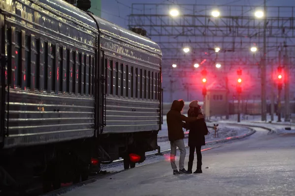 Hai người trẻ cạnh đoàn tàu chở khách tại nhà ga chính Novosibirsk. Gặp gỡ hay chia ly? Hai người trẻ cạnh đoàn tàu chở khách tại nhà ga chính Novosibirsk. Gặp gỡ hay chia ly? - Sputnik Việt Nam