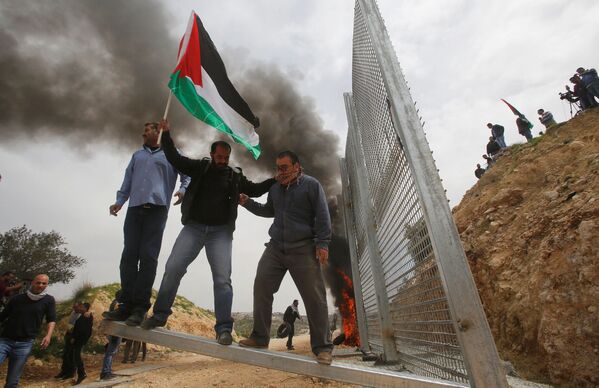 Người Palestine phá hàng rào do người Israel dựng trong cuộc biểu tình phản đối tại thành phố ở Bờ Tây sông Jordan. - Sputnik Việt Nam