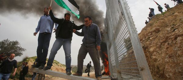 Người Palestine phá hàng rào do người Israel dựng trong cuộc biểu tình phản đối tại thành phố ở Bờ Tây sông Jordan. - Sputnik Việt Nam