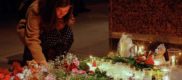 Cô gái thắp ngọn nến ở lối vào sảnh ga tàu điện ngầm Spasskaya, tưởng niệm các nạn nhân trong vụ khủng bố. Cô gái thắp ngọn nến ở lối vào sảnh ga tàu điện ngầm Spasskaya, tưởng niệm các nạn nhân trong vụ khủng bố. - Sputnik Việt Nam