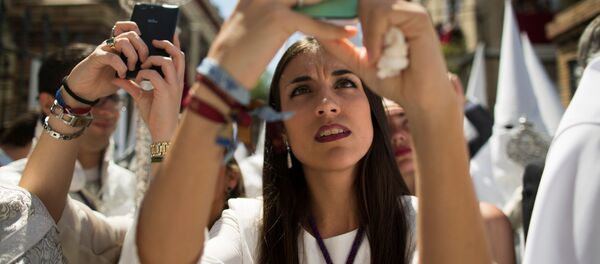 Девушка делает фото во время Страстной недели в испанской Севилье - Sputnik Việt Nam