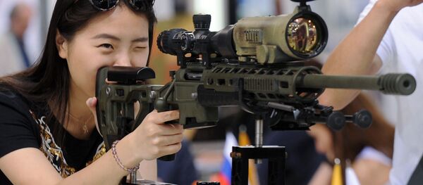 Một vị khách xem vũ khí xạ kích tại MILEX-2017. Một vị khách xem vũ khí xạ kích tại MILEX-2017. - Sputnik Việt Nam