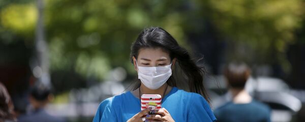 Một cô gái đeo khẩu trang ở Seoul Một cô gái đeo khẩu trang ở Seoul - Sputnik Việt Nam