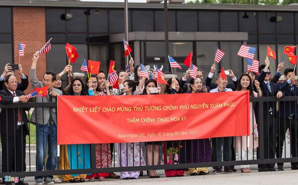 Thủ tướng Nguyễn Xuân Phúc đã bước tới hàng rào sân bay để bắt tay thăm hỏi đông đảo kiều bào đón chào. - Sputnik Việt Nam