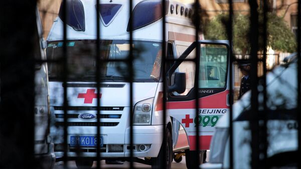 A Chinese police officer stands near an ambulance taking Ji Zhongxin away after his sentencing at the Beijing Chaoyang District Court in Beijing, China, Tuesday, Oct. 15, 2013 - Sputnik Việt Nam