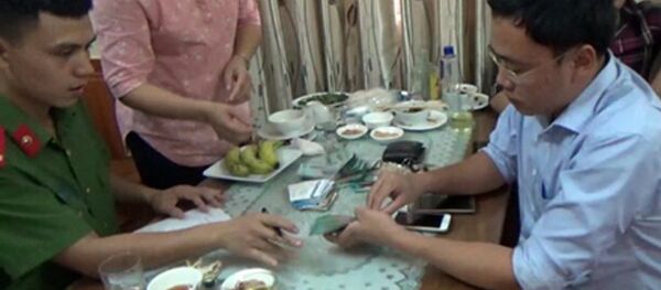 Nhà báo Lê Duy Phong (áo xanh, bên phải) bị công an bắt khi đang dùng bữa tại nhà hàng. Ông Phong được cho là có hành vi nhận tiền của doanh nghiệp tại đây. - Sputnik Việt Nam