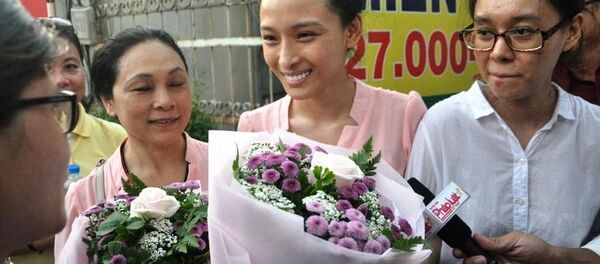 Phương Nga cười rạng rỡ và nhận bó hoa từ người thân sau khi được tại ngoại - Sputnik Việt Nam