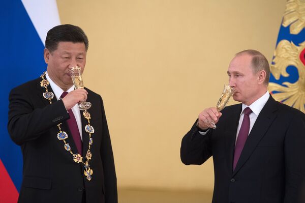 Tổng thống Nga Vladimir Putin và Chủ tịch Trung quốc Tập Cận Bình, người được trao Huân chương Thánh Andrei (trái) trong cuộc gặp. - Sputnik Việt Nam