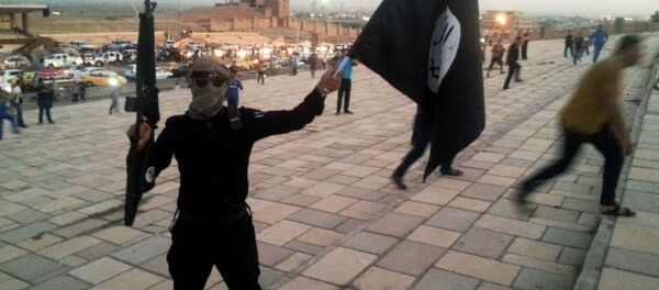 Боевик держит флаг ИГ в городе Мосул Боевик держит флаг ИГ в городе Мосул - Sputnik Việt Nam