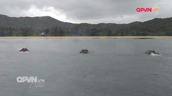 Xe tăng lội nước vận động theo đội hình và khai hỏa vào mục tiêu trên bờ.  - Sputnik Việt Nam