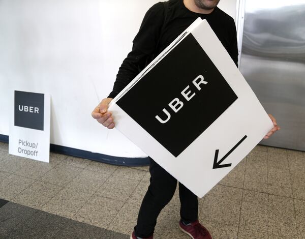 An Uber representative put up signs at LaGuardia Airport in New York, Wednesday, March 15, 2017. - Sputnik Việt Nam