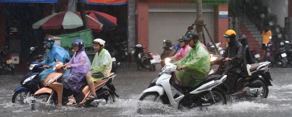 Người đi xe máy ở Hà Nội bị ngập nước do bão nhiệt đới Talas - Sputnik Việt Nam