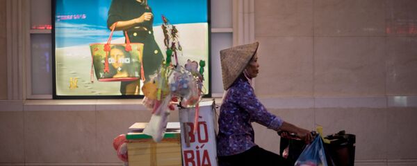 Người bán hàng rong đạp xe ngang qua trung tâm thương mại, Hà Nội, Việt Nam Người bán hàng rong đạp xe ngang qua trung tâm thương mại, Hà Nội, Việt Nam - Sputnik Việt Nam