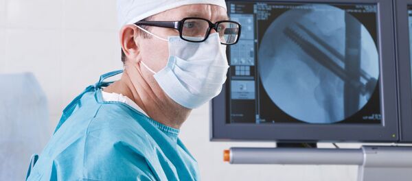 Врач в больнице напротив монитора с рентгеновским снимком Врач в больнице напротив монитора с рентгеновским снимком - Sputnik Việt Nam