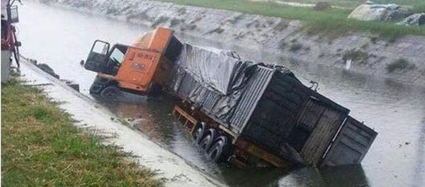Xe container lật ngửa dưới sông sau khi gây tai nạn. - Sputnik Việt Nam