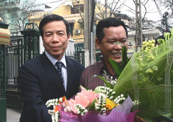 Ông Nguyễn Việt Tiến (trái) nhận hoa từ người thân sau khi Viện KSND Tối cao tuyên bố trắng án. - Sputnik Việt Nam