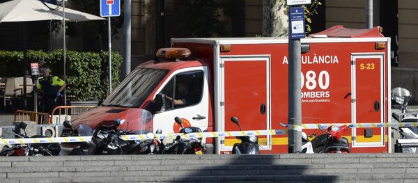 A policeman stands next to an ambulance after a van ploughed into the crowd, injuring several persons on the Rambla in Barcelona on August 17, 2017 - Sputnik Việt Nam