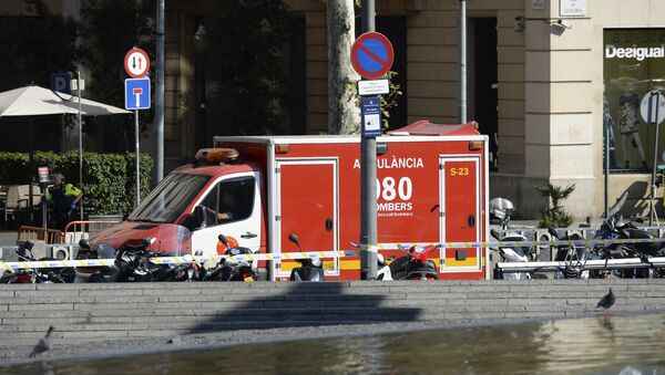 A policeman stands next to an ambulance after a van ploughed into the crowd, injuring several persons on the Rambla in Barcelona on August 17, 2017 - Sputnik Việt Nam