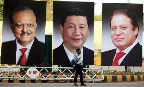 A policeman stands guard next to giant portraits of (L-R) Pakistan's President Mamnoon Hussain, China's President Xi Jinping, and Pakistan's Prime Minister Nawaz Sharif, displayed along a road ahead of Xi's visit to Islamabad - Sputnik Việt Nam