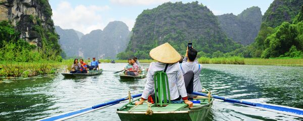Khách du lịch trên thuyền trong cuộc du ngoạn dọc sông Ngô Đồng ở Việt Nam Khách du lịch trên thuyền trong cuộc du ngoạn dọc sông Ngô Đồng ở Việt Nam - Sputnik Việt Nam