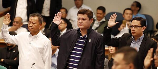 Cục trưởng Hải quan Philippines Isisdro Lapena (trái), Phó Thị trưởng Davao Paolo Duterte - con trai Tổng thống Rodrigo Duterte (giữa) và Maneses Carpio, con rể ông Rodrigo Duterte (phải), tuyên thệ trong buổi điều trần tại Thượng viện hôm 7.9. - Sputnik Việt Nam