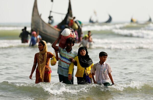 Dân tị nạn người Rohingya đổ lên bờ với đồ đạc của họ sau khi vượt biên giới đường biển giữa Bangladesh và Myanmar. - Sputnik Việt Nam